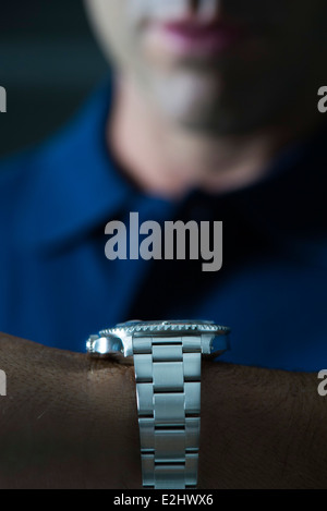 Man wearing wristwatch, checking time Stock Photo