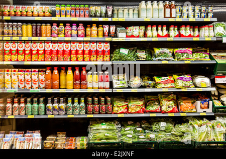 Shelf with food in a supermarket. Refrigerated, fruit juices, salad, vegetables, packed in plastic,