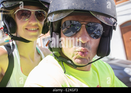 man woman couple helmet helmets sunglasses 'having fun' driving riding smiling smile kiss selfie Stock Photo