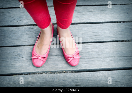 Girls beautiful pink shoes over wooden deck Stock Photo