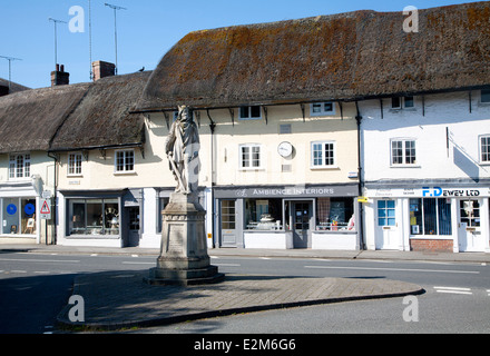 King Alfred statue in the market place and thatched shop buildings in the village of Pewsey, Wiltshire, England Stock Photo