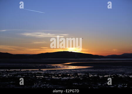 Swansea, UK. Saturday 21 June 2014  Pictured: The sun reflects on the wet sandy beach as it rises over Swansea marking the Summer Solstice and the year's longest day. Credit:  D Legakis/Alamy Live News Stock Photo