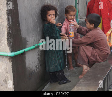 The children of Afghan refugee playing near  their refugee camp on the eve of World Refugees Day in Lahore, Pakistan. The UNHCR said there were about 51.2 million forcibly displaced people last 2013, with an 11% increase compared year 2012. (Photo by Rana Sajid Hussain/Pacific Press) Stock Photo