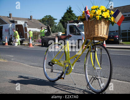 Women's floral decorated yellow bicycle in York, Yorkshire, UK. 21st June, 2014.  Maintenance crew carrying out Saturday Road repairs on the  Tour de France route.  A total of £4million has been allocated by eight Yorkshire councils to get the region’s roads repaired and the route ready for Tour de France in July.  The money is being spent to ensure that the 389 kilometres of tarmac to be used for the 2014 Tour’s Grand Depart, will be pothole free. The route is now being lined with yellow flowers, wickerwork baskets, bunting and bikes. Stock Photo