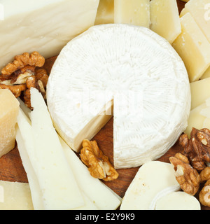 assorted cheeses on wooden plate close up Stock Photo