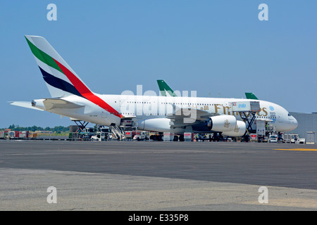 Emirates logo on Airbus A380 double deck wide body four engine jet airplane airport apron stand ground crew in attendance Rome Fiumicino Airport Italy