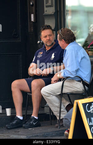 Russell Crowe smokes a cigarette while having a conversation with a friend in Tribeca  Featuring: Russell Crowe Where: New York Stock Photo