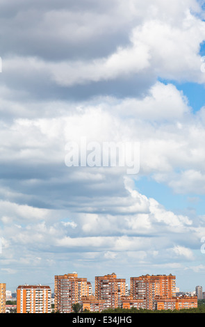 low woolpack clouds over city in summer day Stock Photo