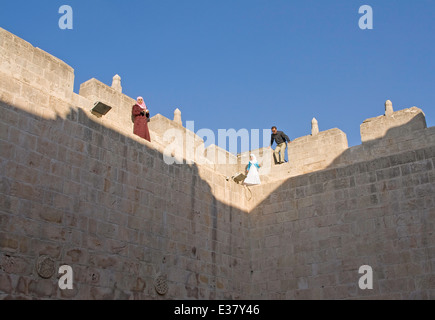 A woman, man and child walk the ramparts of the citadel in Aleppo, Syria Stock Photo