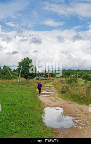 Rural lifestyle 2013. The woman picked berries in the wood and go home. Stock Photo