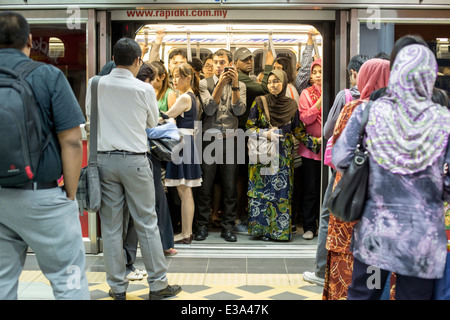 Commuters wait on a train at a RapidKL LRT station in Kuala Lumpur, Malaysia Stock Photo