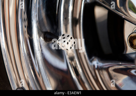 Dice tire valve cover on chrome rim Stock Photo