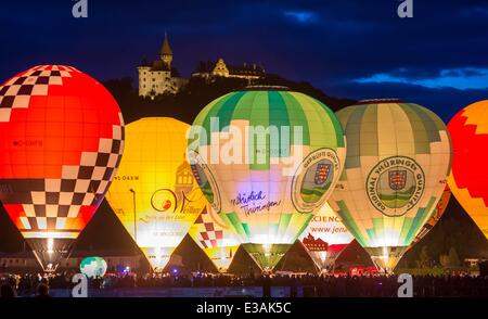 Hot air balloons glow during the so-called 'Balloon Glowing' event within the 20th Montgolfiade below the Heldburg Castle, in Bad Colberg-Heldburg, Germany, during the dusk hours on 20 June 2014. The annual event is held since 1994 and this year was attended by the entire German national balloon team. Photo: Michael Reichel/dpa Stock Photo