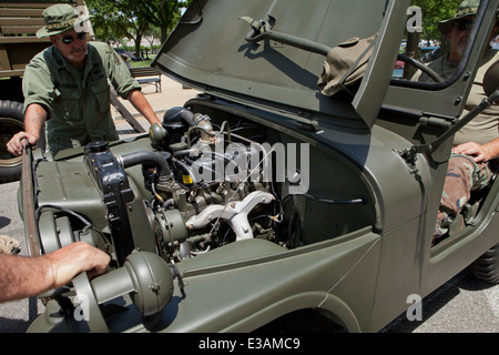 WWII era US Army reenactors looking under the hood of Willys Jeep - USA Stock Photo