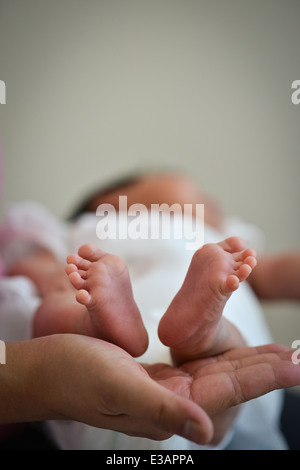 Baby Infant Precious Feet Over Mother's Hand - Innocence Concept Stock Photo