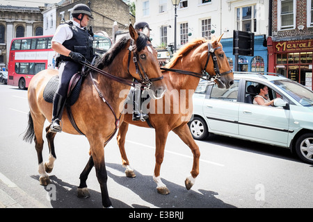 Two mounted Metropolitan Police Officers patrolling the street of Greenwich. Stock Photo
