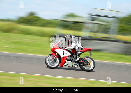 Motorcycles racing around Castle Combe Circuit at their Grand National Motorcycle Race Meeting weekend. Stock Photo