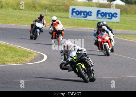 Motorcycles racing around Castle Combe Circuit at their Grand National Motorcycle Race Meeting weekend. Stock Photo