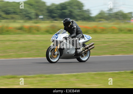 Motorcycles racing around Castle Combe Circuit at their Grand National Motorcycle Race Meeting weekend. Stock Photo