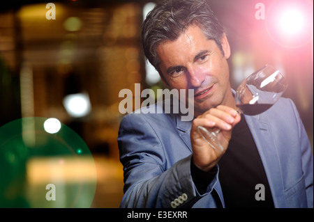 Winegrower in wine-cellar holding glass of wine Stock Photo