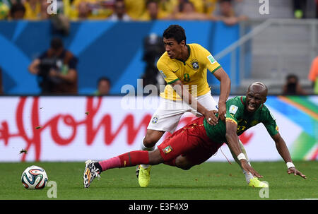 Brasilia, Brazil. 23rd June, 2014. Cameroon's Stephane Mbia (R) and Brazil's Paulinho vie for the ball during the FIFA World Cup 2014 group A preliminary round match between Cameroon and Brazil at the Estadio Nacional in Brasilia, Brazil, 23 June 2014. Photo: Marius Becker/dpa/Alamy Live News Stock Photo