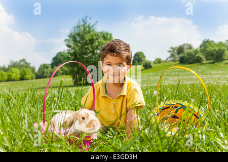Boy with rabbit and two baskets in the park Stock Photo