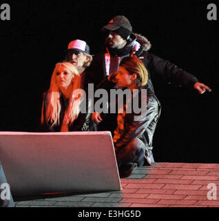 Britney Spears filming the promo for her new single 'Perfume' in Lancaster, California. The pop star films a scene kissing and cuddling with her co-star Alexander Kjellevik on a roof top of an old gas station, who also showers the singer with money.  Feat Stock Photo