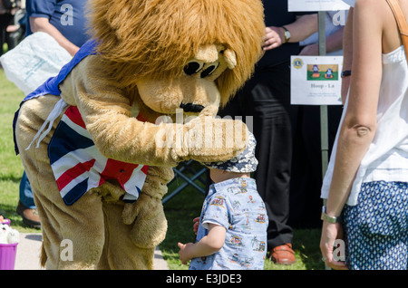 Man in a lion costume patting a small boy on his head Stock Photo