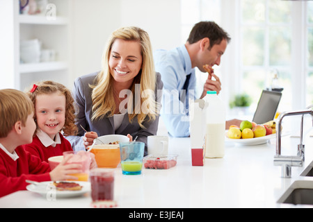 Family Having Breakfast In Kitchen Before School And Work Stock Photo