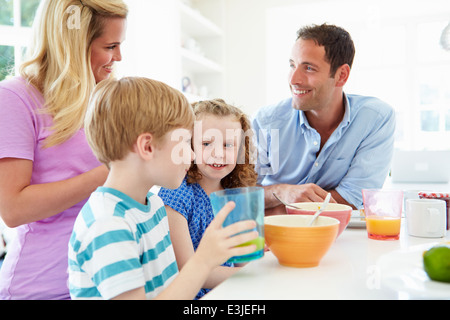 Family Having Breakfast In Kitchen Together Stock Photo