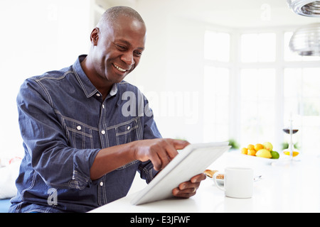 African American Man Using Digital Tablet At Home Stock Photo