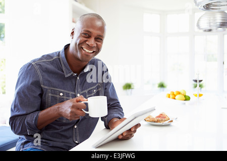African American Man Using Digital Tablet At Home Stock Photo