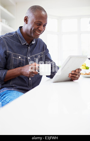 African American Man Using Digital Tablet At Home Stock Photo
