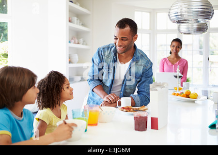 Family Having Breakfast In Kitchen Together Stock Photo