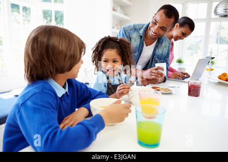 Family Having Breakfast In Kitchen Before School Stock Photo