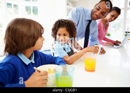 Family Having Breakfast In Kitchen Before School And Work Stock Photo