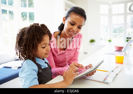 Mother And Child Using Digital Tablet For Homework Stock Photo