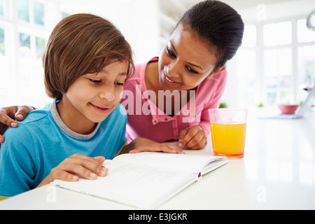 Mother helping her son with homework on sofa at home Stock Photo - Alamy