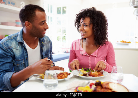 Young African American Couple Eating Meal At Home Stock Photo