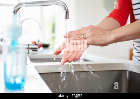 Close Up Of Woman Washing Hands In Kitchen Sink Stock Photo