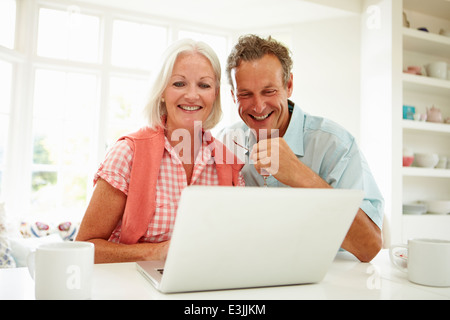 Smiling Middle Aged Couple Looking At Laptop Stock Photo