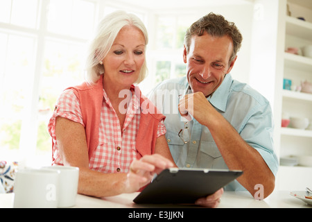 Smiling Middle Aged Couple Looking At Digital Tablet Stock Photo