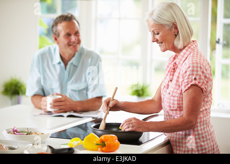 Middle Aged Couple Cooking Meal In Kitchen Together Stock Photo