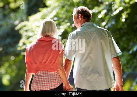 Rear View Of Middle Aged Couple Walking Along Country Lane Stock Photo