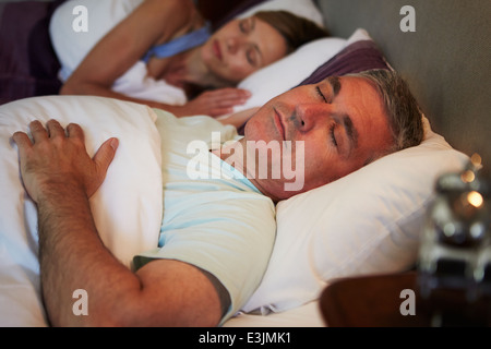 Middle Aged Couple Asleep In Bed Together Stock Photo