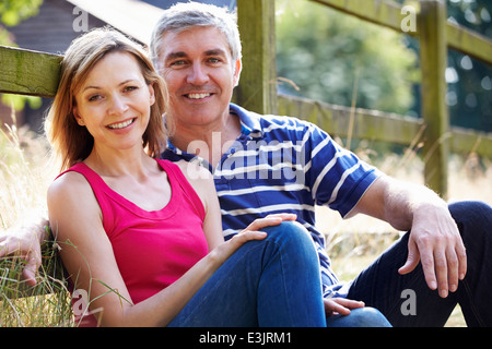 Romantic Middle Aged Couple Relaxing On Walk In Countryside Stock Photo
