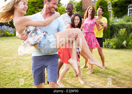 Friends Relaxing In Summer Garden Together Stock Photo