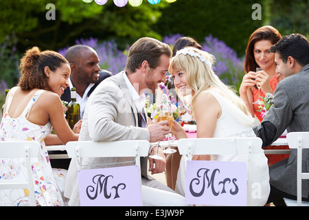 Bride And Groom Enjoying Meal At Wedding Reception Stock Photo