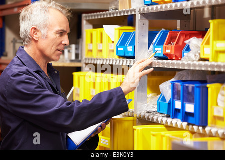 Worker Checking Stock Levels In Store Room Stock Photo