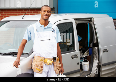 Decorator Wearing Overalls Standing Next To Van Stock Photo